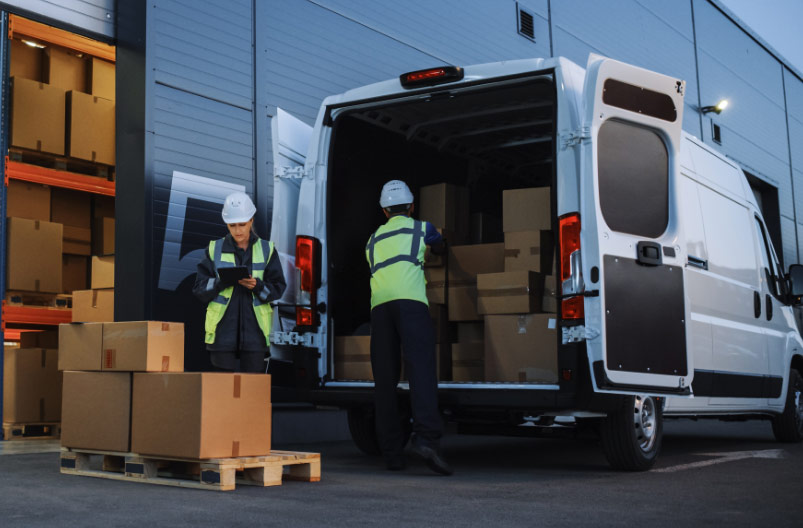 photo of two delivery drivers unloading packages out of a white van. Redundancy rights Ireland