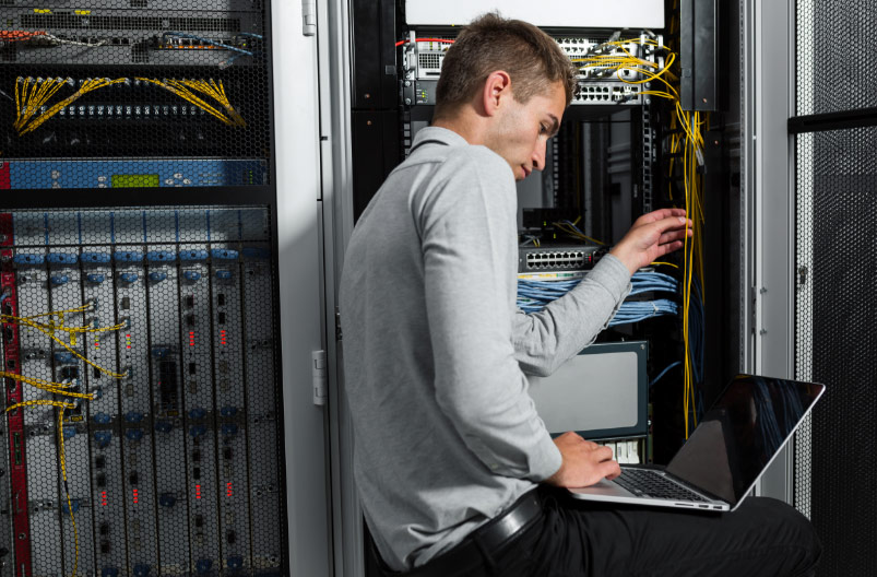 Man in employment wearing a grey shirt working on a computer in Ireland
